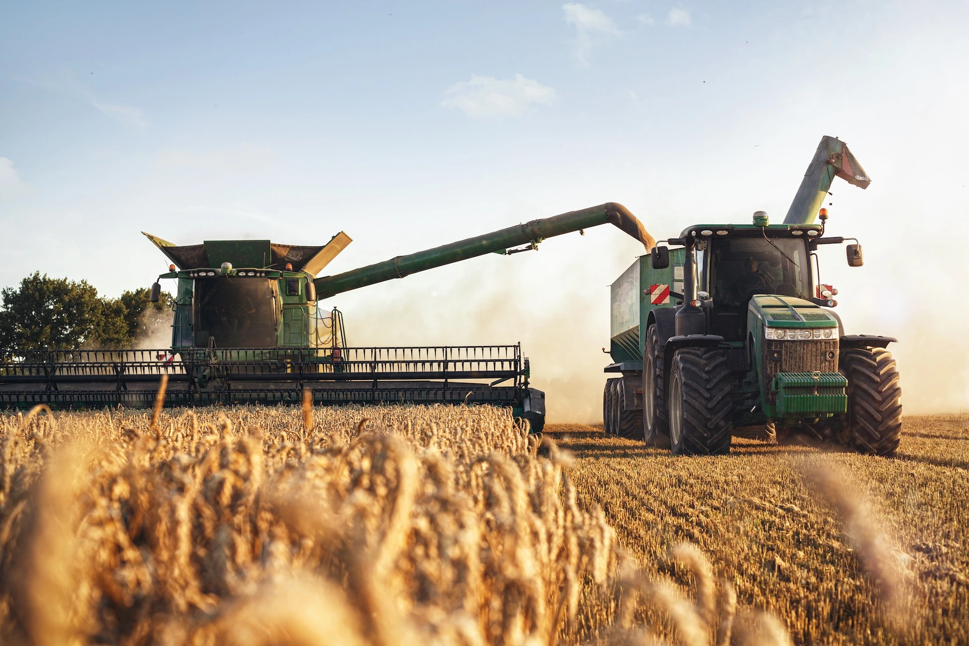 Tractor and combine harvester in a field
