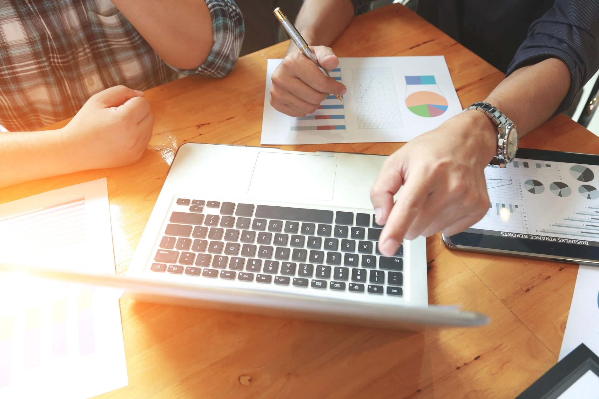 Person pointing at a laptop screen whilst annotating a chart indicating making tax digital